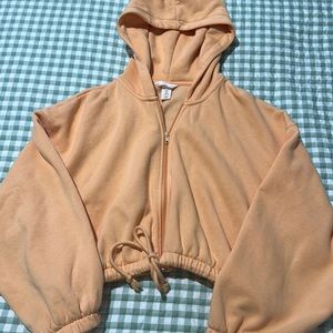 H&M light orange cropped zip up hoodie. Size medium, cinched drawstring tie!